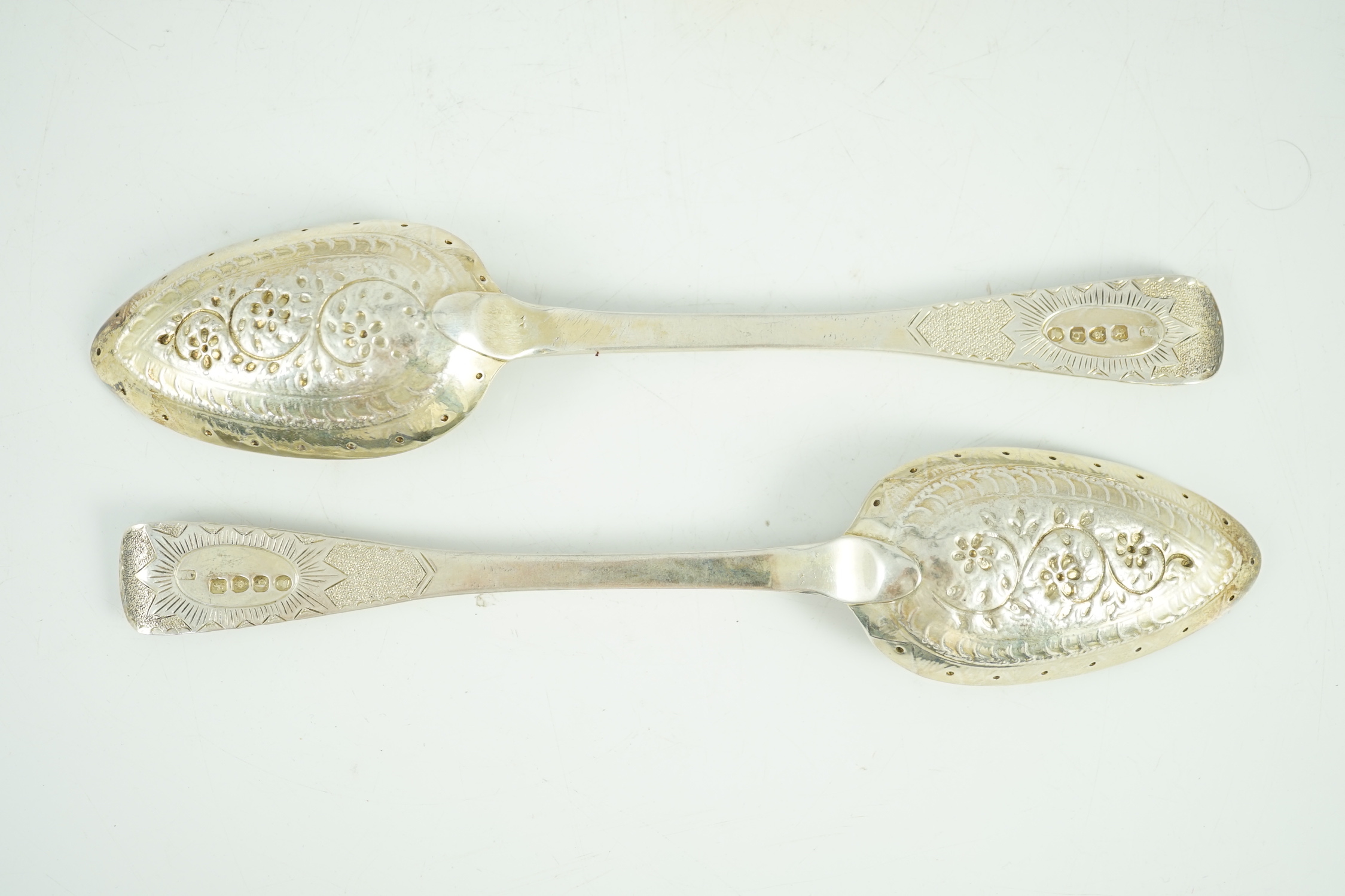 A cased set of four late George III embossed and engraved parcel gilt silver Hanovarian pattern serving spoons, William Chawner II?